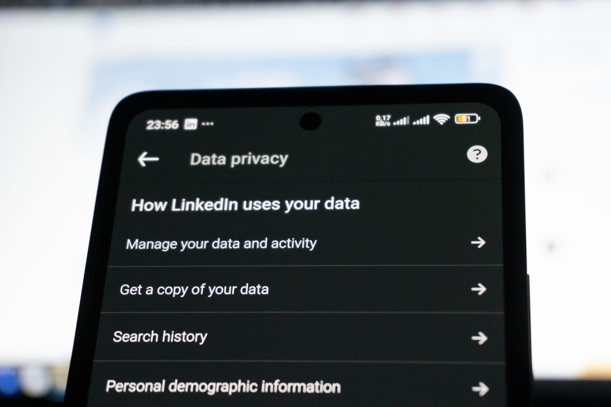 Teléfono mostrando la pantalla «How LinkedIn uses your data», ilustrando la gestión del consentimiento de datos.