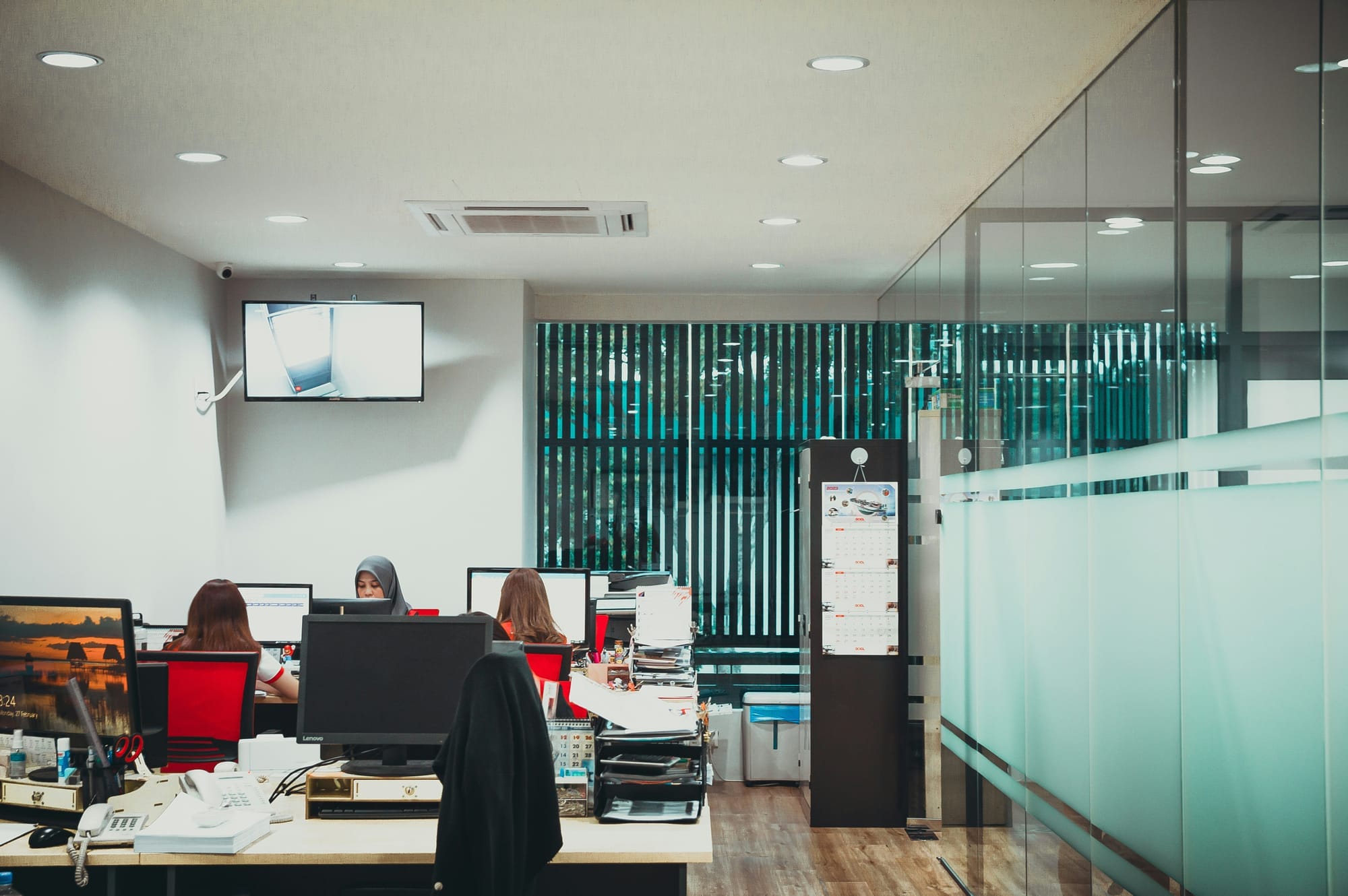 Oficina con personas trabajando en computadores, simbolizando el cumplimiento mínimo exigido por la Ley 21.719.