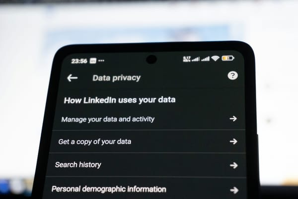 Teléfono mostrando la pantalla «How LinkedIn uses your data», ilustrando la gestión del consentimiento de datos.